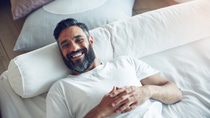 Portrait of a mature man relaxing on his bed at home