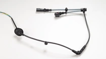 Industrial cable harness with connectors and attached sensor components on a light background.