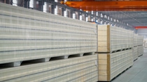 Stacked insulated sandwich panels ready for transport and installation in energy-efficient building applications.