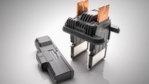 Two black electrical components created using Ultramid Advanced with copper and metal connectors on a reflective surface. Two black electrical components created using Ultramid Advanced with copper and metal connectors on a reflective surface.