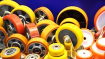 Group of different size and diameter industrial small wheels in warm yellow and orange colors for sale. Heavy Duty Fixed Polyurethane Industrial trolley Swivel Rubber Caster Wheels.