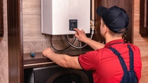 Plumber adjusts gas boiler before operating. Plumber adjusts gas boiler before operating.