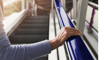 Hand holding a blue escalator handrail beside an escalator.