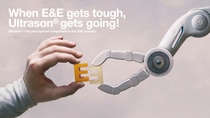 Human and robotic hand holding two pieces together Human and robotic hand holding two pieces together