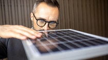 man touching and checking photovoltaic panel while working on solar power station on sunny day. Solar energy concept man touching and checking photovoltaic panel while working on solar power station on sunny day. Solar energy concept
