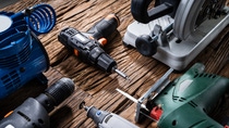 Various Power Tools Laying On Wooden Desk