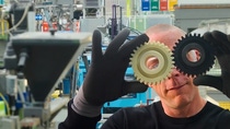 Man holding gear wheels in front of his eyes Man holding gear wheels in front of his eyes