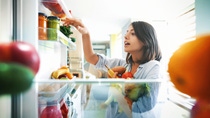 Closeup of a cheerful young couple picking some fruit and veggies from the fridge to make some healthy breakfast on Sunday morning. Shot from inside the working fridge. Closeup of a cheerful young couple picking some fruit and veggies from the fridge to make some healthy breakfast on Sunday morning. Shot from inside the working fridge.