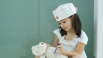 Little girl in nurse hat giving teddy bear shot Little girl in nurse hat giving teddy bear shot