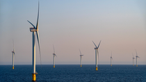 Multiple offshore wind turbines operate in a marine environment, generating renewable electricity from wind resources.
