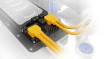 High‑voltage connectors with bright yellow cables attached to an electric vehicle’s battery system.
