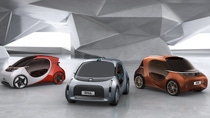 Three futuristic GAC electric concept cars in red, silver, and bronze displayed in a modern, geometric indoor showroom. Three futuristic GAC electric concept cars in red, silver, and bronze displayed in a modern, geometric indoor showroom.