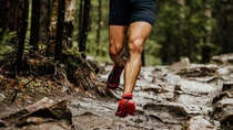 wet feet runner athlete running on trail stones in forest