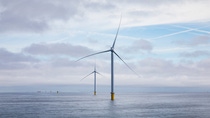 A wind farm under construction. Two wind turbines in a blue ocean. In the backdrop, you can find three more monopile foundations and a ship. A wind farm under construction. Two wind turbines in a blue ocean. In the backdrop, you can find three more monopile foundations and a ship.