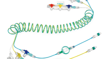 Coiled multi-lumen medical tubing set with connectors, stopcocks, and color-coded lines.