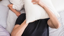 People, family and morning concept - happy child with parents waking up in bed at home