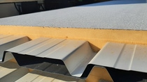 Steel-faced sandwich panel with a rigid PUR foam core, combining structural strength and thermal insulation.