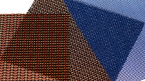 Overlapping mesh textile samples in blue, gray, and multicolored patterns.