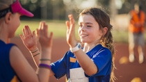 Two girls are high fiving after a difficult race in athletics club.