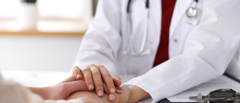 Hand of doctor  reassuring her female patient. Medical ethics and trust concept