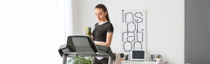 Sporty young woman training on treadmill at home