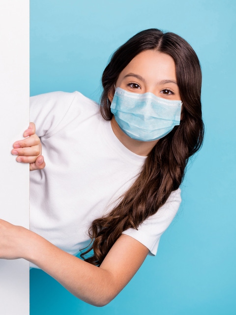Close-up portrait cheerful cheery wavy-haired girl demonstrating empty space ad advert point finger covid outbreak news wear medical mask isolated bright shine blue color background; Shutterstock ID 1814429318; purchase_order: 07032023; job: Präsentation; client: BASF SE, Global Communications Plastic Additives, Lilian Hoh; other: BASF SE, GBH/IM - D211, Matthias Baque