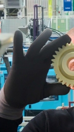 Man holding gear wheels in front of his eyes