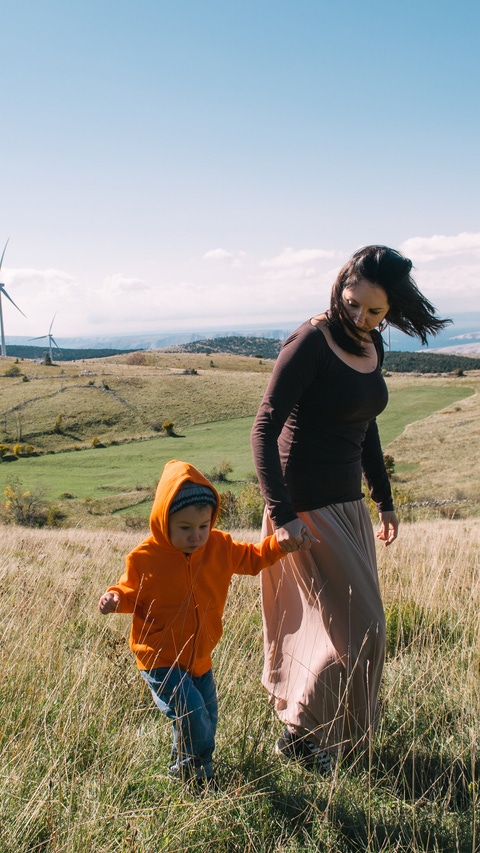 Mother and son in nature. Wind turbines in the background. Mother and son in nature. Wind turbines in the background.