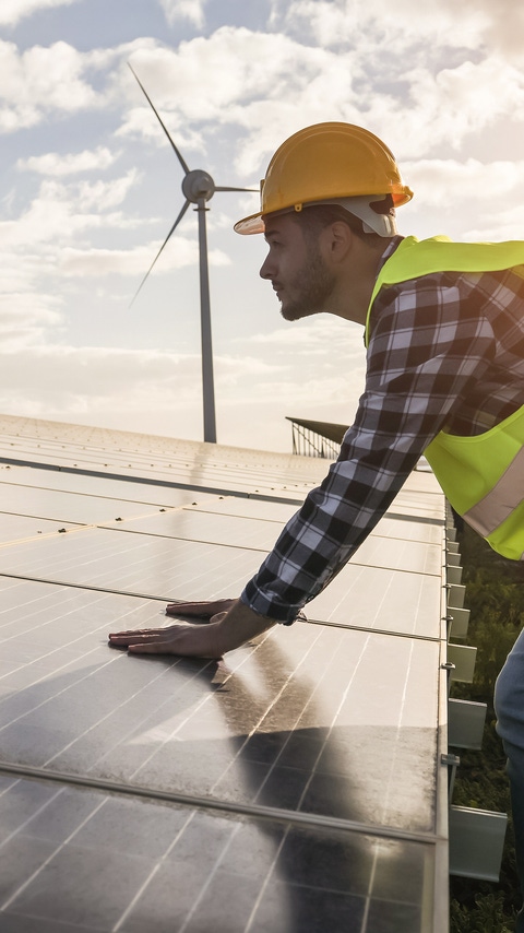 Man working for solar panels and wind turbines - Renewable energy concept - Focus on male worker hands Man working for solar panels and wind turbines - Renewable energy concept - Focus on male worker hands