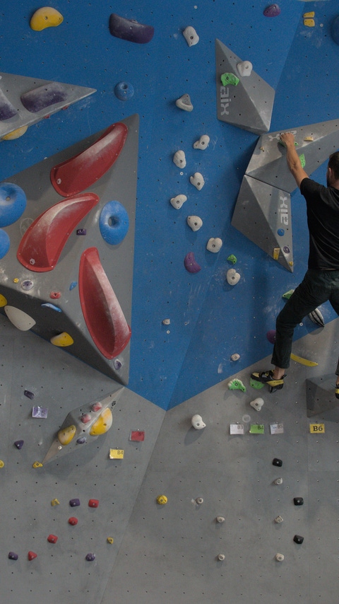 Man climbing a climbing wall in the gym