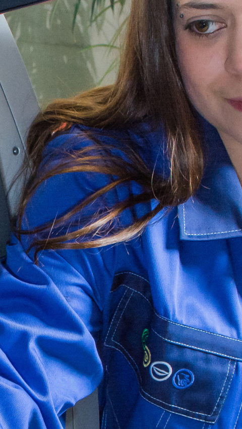 Woman holding a bottle standing in front of a machine 