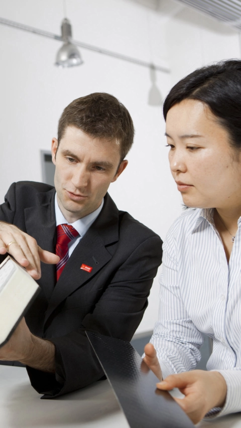 Development engineers Rie Kaneko and Torsten Hensel discuss the structure of the lightweight comfort seat using a cross-section model. By means of the e-textile technology used, the seat heating can be directly embedded in the textile and is thus close to the body. Elastoflex® flexible foams in the sitting areas save up to 20 percent weight and at the same time provide ergonomic advantages by means of various hardness zones. Print free of charge. Copyright by BASF.