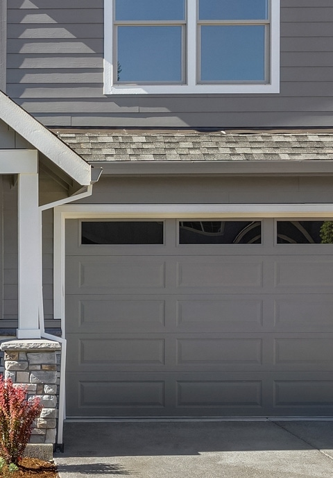 facade of home with manicured lawn, and backdrop of trees and blue sky facade of home with manicured lawn, and backdrop of trees and blue sky