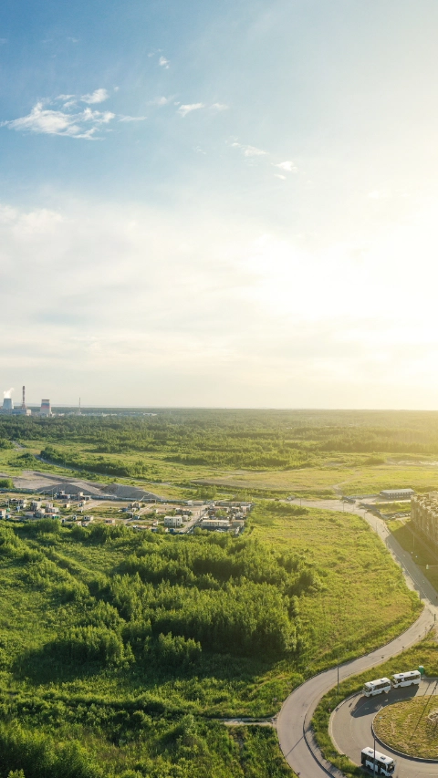 Summer forest and green field near city. Panorama. Nobody. Aerial view from drone