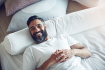 Portrait of a mature man relaxing on his bed at home