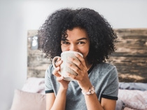 Cropped shot of a young woman enjoying a hot beverage while sitting in her room